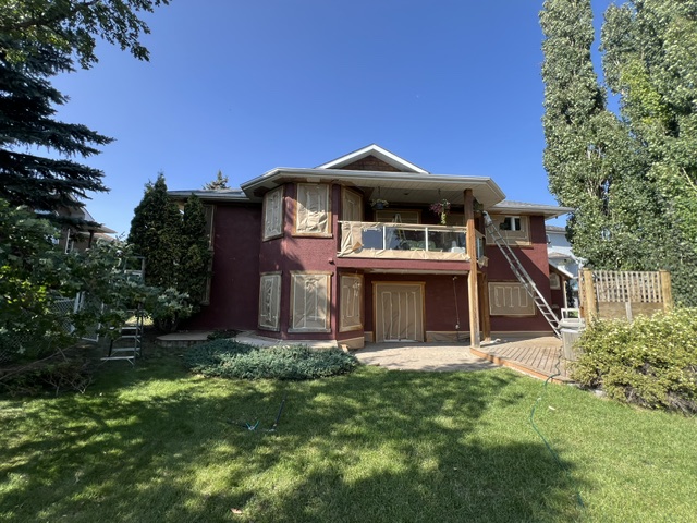 Red stucco house exterior before painting in Calgary
